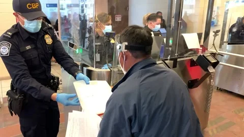 Mexican immigrant passing documents to CBP official at processing center Stock Footage 150425828