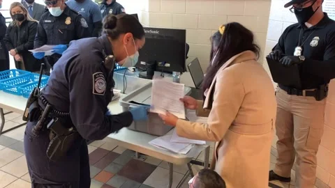 Mexican immigrant passing documents to CBP official at processing center Stock Footage 150425888