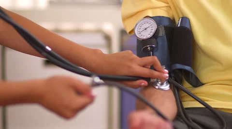 Mexican nurse checking patient's blood pressure Stock Footage