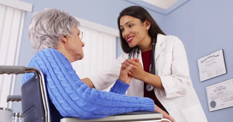 Mexican woman doctor comforting elderly patient Stock Footage