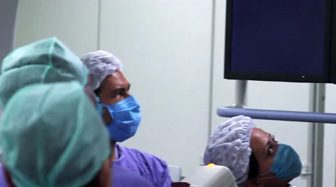 Mexico, 2014: CLOSE UP-PAN RIGHT. Surgeons looking a monitor during surgery. Stock Footage 48480316