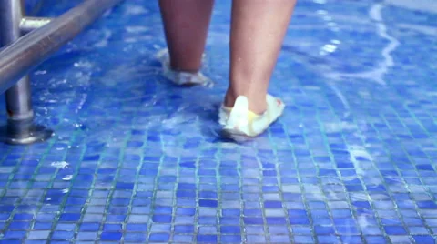 Mexico, 2014: FULL SHOT-HANDHELD SHOT. Woman doing rehab exercises inside a pool Stock Footage 45010429