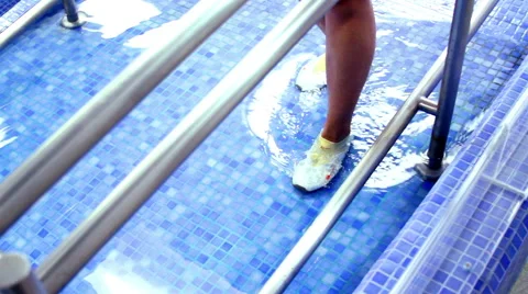 Mexico, 2014: FULL SHOT-HANDHELD SHOT. Woman doing rehab exercises inside a pool Stock Footage 45011828
