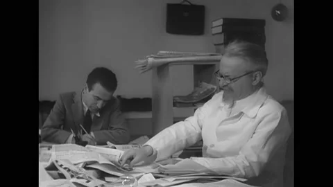 MEXICO CITY - 1937 - Leon Trotsky reads and writes as his desk with his lawyer Stockbeeldmateriaal 323084547