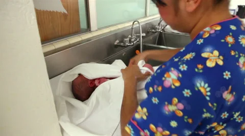 Mexico: MEDIUM SHOT-BACK SHOULDER. Nurse dried a newborn with a towel. Stock Footage 48939593