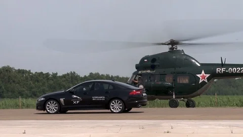 MI-2 helicopter and black Jaguar machine stand side by side at launch position. Stock Footage 106370315
