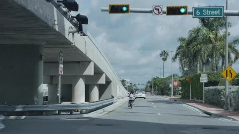 Miami road traffic with cloudy sky at 6 street. Motorcycle and car. Road signs, Stock-Footage 110769739