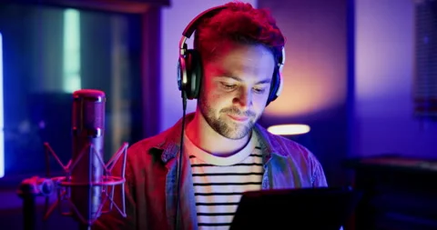 Mic, man and reading with tablet for broadcast, talk show and script for podcast Stockbeeldmateriaal 332322692