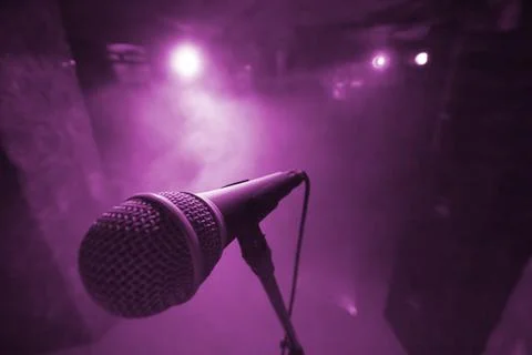 Mic on stage with violet light background Stock Photos
