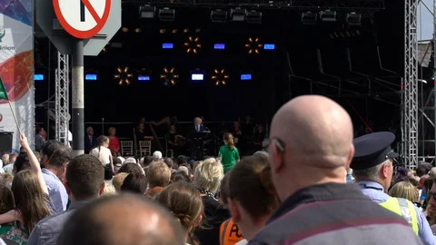 Michael D Higgins talks on stage, a flag waves Stock Footage 127584930