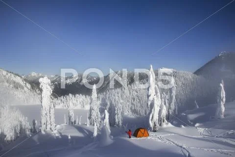 Michael Hanson Walks Through Deep Powder To His Campsite In The Snow Covered