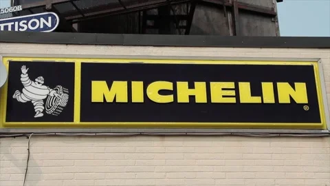 Michelin logo horizontal rectangle sign with white tire mascot on building Stock Footage 249102968