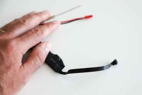 A micro camera is held between the fingers of one hand Stock Photos