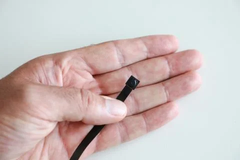 A micro camera is held between the fingers of one hand Stock Photos
