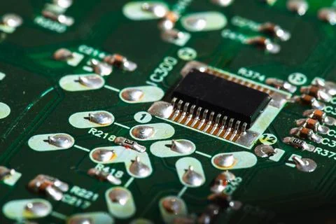 Micro chip and capacitors mounted on a green printed circuit board, close up 스톡 사진