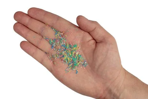 Micro plastic on a man's hand, top photo. Dots of colored plastic on the hand Stock-Fotos