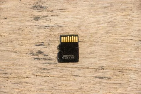 Micro SD card back side close up shot on a wooden surface. Action camera ac.. Stock Photos