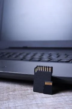 Micro SD memory card adapter on laptop background on the wooden table. close Stock Photos