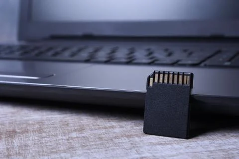 Micro SD memory card adapter on laptop background on the wooden table. close Stock Photos