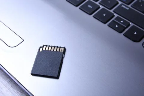 Micro SD memory card adapter on grey laptop keyboard on the wooden table. clo Stock Photos
