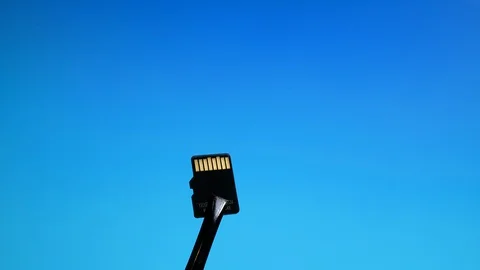 Micro SD memory card close-up on blue background sandwiched in crimper Video stock 129443491