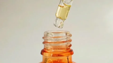 Micro shot of bottle pipette dropper liquid yellow-orange vitamin c or retinol Stock Footage 284535072