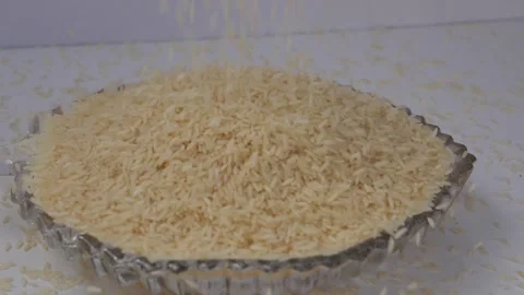 Micro shot of dropping rice over a glass filled with rice Vidéo 147694199