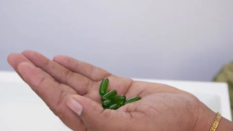 Micro shot dropping tablets over a hand, view of dropping tablets Video stock 147696941