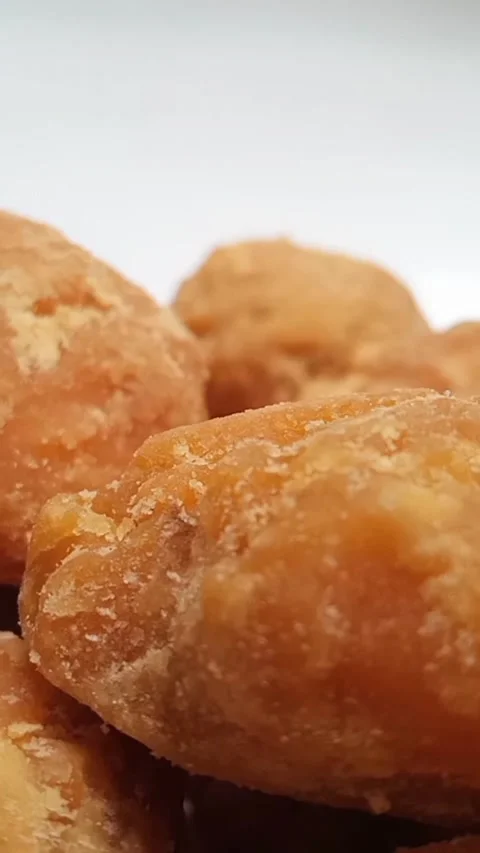 Micro shot of Jaggery or Gur pieces rotating on white background. brown sugar Stock Footage 283088713
