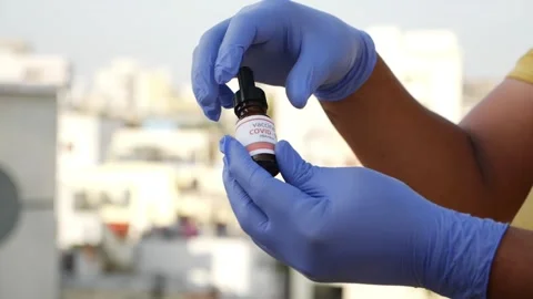 Micro shot of opening covid-19 vaccine drop bottle cap Stock-Footage 147697186
