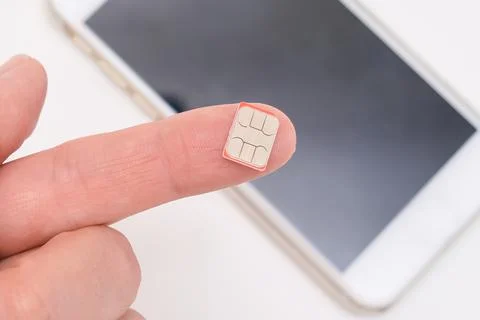 Micro sim card for mobile communication on a finger close up, wireless Stock Photos