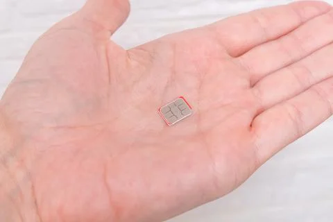 A micro sim card on a palm, hand, person holding a simcard Stock Photos
