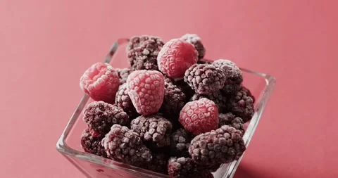 Micro video of close up of raspberries in glass bowl with copy space on red Stock Footage 331307403