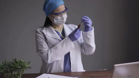 Microbiologist doctor examines the test tubes with the blood of the diseased for Stock Footage 130132474