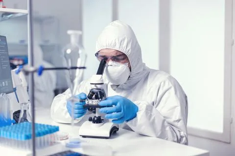 Microbiologist examining virus evolution using high tech microscope Stock Photos