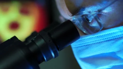 Microbiologist Looking At A Virus Blood Sample Through A Microscope Stock Footage 131073752