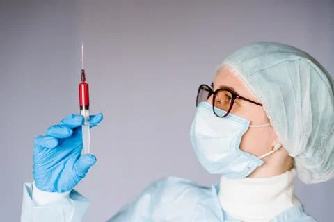 Microbiologist testing a biological sample blood contaminated by Coronavirus. Stock Photos
