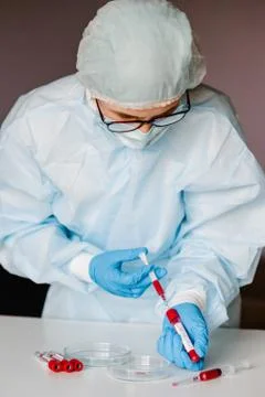 Microbiologist testing a tube with biological sample, syringe with blood cont Stock Photos