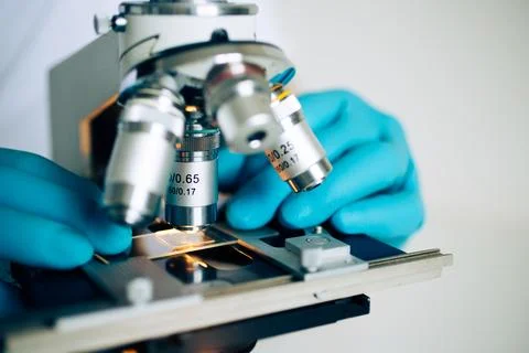 Microbiologist using laboratory microscope Stock Photos