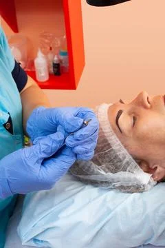 Microblading in a cosmetologist's studio - Permanent eyebrow makeup Stock Photos