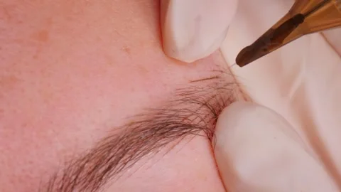 Microblading expert creates ideal eyebrow shape in salon Stock Footage 282528634