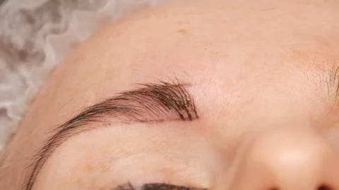 Microblading eyebrow tattoo, permanent makeup. Master in gloves, using special Stock Footage 120192045