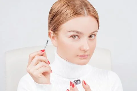Microblading eyebrows, well-groomed eyebrows, woman applies paint henna on ey Stock Photos