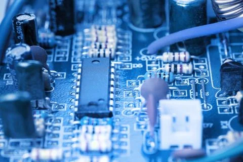 Microchip, capacitors, resistors on a blue computer board. Industrial backgro Stock Photos