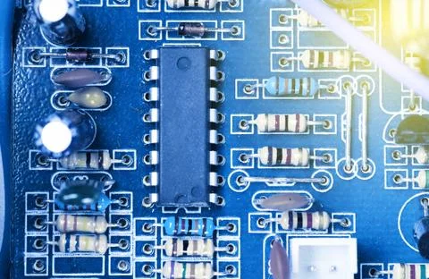 Microchip, capacitors, resistors on a blue computer board. Industrial backgro Stock Photos