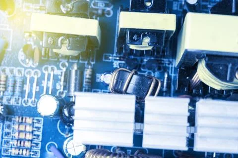 Microchip, capacitors, resistors on a blue computer board. Industrial backgro Stock Photos