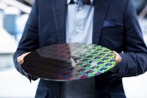 Microchip factory manager looking at microelectronic semiconductor substrate Stock Photos