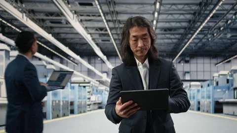 Microchip factory senior manager testing silicon wafer batches with tablet Stock Footage 333392430