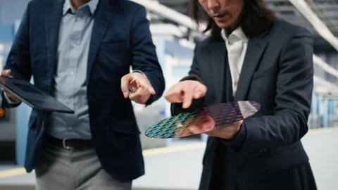 Microchip factory senior manager testing silicon wafer batches with tablet Stock Footage 333392570