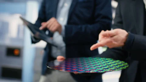 Microchip factory senior manager testing silicon wafer batches with tablet Stock Footage 333395033